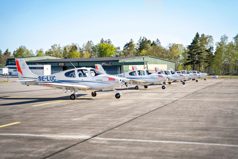 Sex stycken Cirrus SR20-plan står på rad på flygbanan på Ljungbyheds Trafikflyghögskola. Foto.