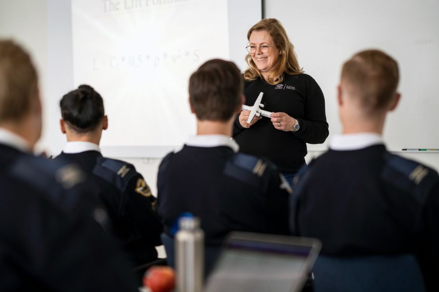 Kvinnlig lärare undervisar flygstudenter i ett klassrum. Foto.
