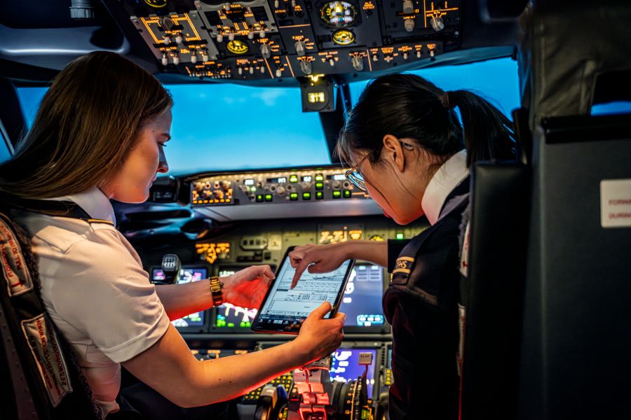 Två kvinnliga studenter i cockpit. Foto.
